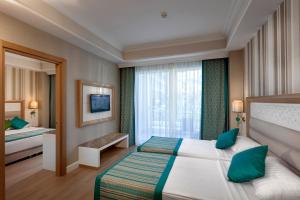 a hotel room with a bed and a window at Karmir Resort & Spa - Ultra All Inclusive in Kemer