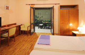 een kamer met een bed, een bureau en een tafel bij Apartments Magda in Cavtat