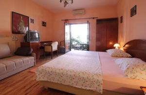 1 dormitorio con cama, sofá y TV en Apartments Magda, en Cavtat