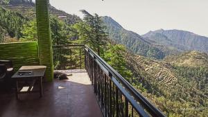 uma varanda com vista para uma montanha em Dhanaulti Jungle Resort em Dhanaulti