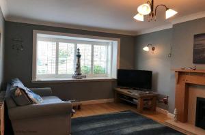 a living room with a television and a fireplace at The Afton in Totland