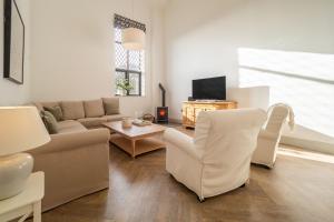 sala de estar con sofá, sillas y TV en Glencairn House, en Thorpeness