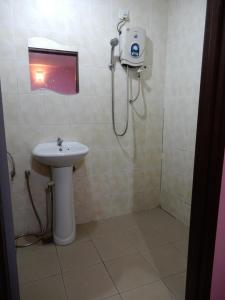 uma casa de banho com um chuveiro, um lavatório e um WC. em LA MOTEL em Sungai Petani