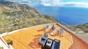 a balcony with chairs and a view of the ocean at Madeira Island Villa Oceane Ribeira Brava in Ribeira Brava