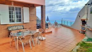 a balcony with a table and chairs and the ocean at Madeira Island Villa Oceane Ribeira Brava in Ribeira Brava