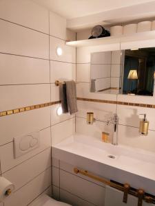 a white bathroom with a sink and a mirror at Ravissant Studio neuf, entièrement equipé, fonctionnel de 40 m2 avec entrée indépendante dans la campagne campagnes in Massonnens