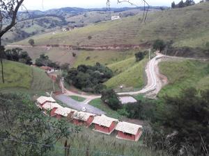 un groupe de maisons sur une colline avec une route sinueuse dans l'établissement POUSADA ESTÂNCIA DAS CACHOEIRAS, à Cunha