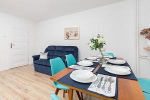 a dining room with a table and blue chairs at City Center Apartment Gdynia by Renters in Gdynia