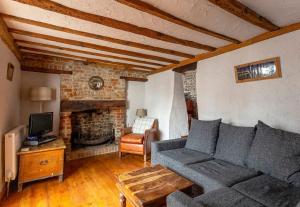 - un salon avec un canapé et une cheminée dans l'établissement Bay Cottage By The Sea in Broadstairs., à Broadstairs