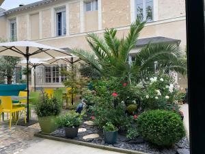 un giardino con fiori e piante di fronte a un edificio di Hôtel Relais du Loir a La Flèche