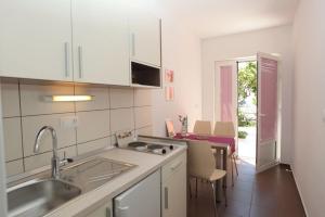 cocina con fregadero y mesa con sillas en Apartment in Podgora with sea view, terrace, air conditioning, WiFi 849-3, en Podgora