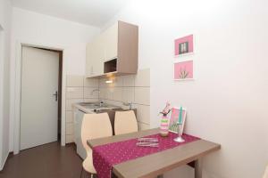 cocina con mesa y mantel rosa en Apartment in Podgora with sea view, terrace, air conditioning, WiFi 849-3, en Podgora