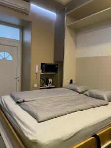 een groot wit bed in een kamer met een raam bij Small Home Budapest Dráva in Boedapest