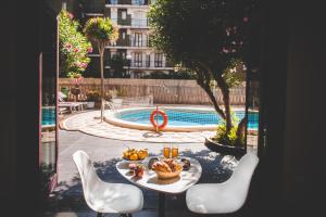 a table with a bowl of fruit on it next to a pool at Ligure Residence in Pietra Ligure