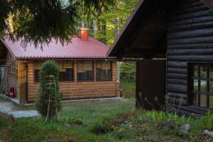 une cabane en rondins avec un toit rouge dans l'établissement Kuća za odmor Curl, à Delnice