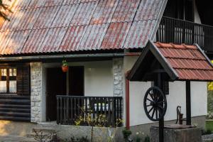 a small house with a rusty roof and a wheel at Kuća za odmor Curl in Delnice