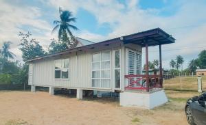 Kamalia Villas في كامبونج بيناريك: منزل صغير مع شرفة على طريق ترابي