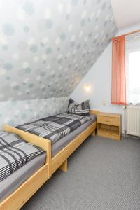 a bedroom with two beds and a window at Ferienhaus Elfriede Coordes in Moorweg