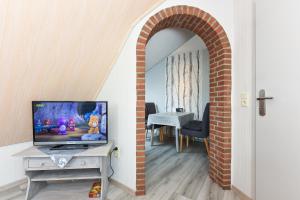 a room with an archway with a television on a table at Ferienhaus Elfriede Coordes in Moorweg