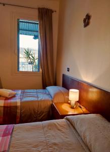 Volpago del MontelloにあるLocanda Caffe Sportのベッドルーム1室(ベッド2台、窓付)