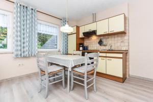a kitchen and dining room with a table and chairs at Ferienhaus Elfriede Coordes in Moorweg