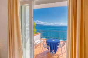 a balcony with a table and a view of the ocean at Hotel Cetus in Cetara