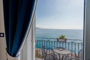 a balcony with a table and chairs and the ocean at Hotel Cetus in Cetara