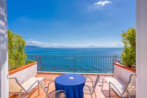 a balcony with a table and chairs and a view of the water at Hotel Cetus in Cetara