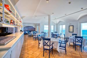 a restaurant with tables and chairs and the ocean at Hotel Cetus in Cetara