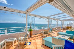a balcony with chairs and tables and the ocean at Hotel Cetus in Cetara