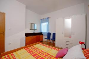 een slaapkamer met een bed en een bureau met blauwe stoelen bij Apartment in Kastel Sucurac with sea view, balcony, air conditioning, WiFi 570-1 in Kaštela