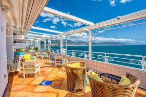 a balcony with chairs and tables on a cruise ship at Hotel Cetus in Cetara