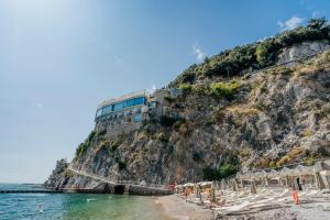 a building on a cliff next to the water at Hotel Cetus in Cetara