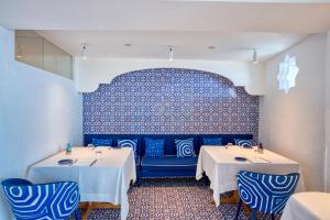 a restaurant with two tables and a blue wall at Hotel Cetus in Cetara