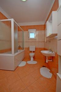 uma casa de banho com um WC, um lavatório e uma banheira em Apartment in Kastel Sucurac with sea view, balcony, air conditioning, WiFi 570-3 em Kaštela