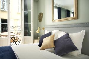 a bedroom with a bed with blue and white pillows at Studio Opéra by Studio prestige in Paris