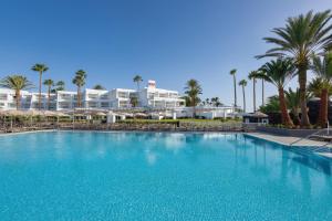 a large swimming pool in front of a resort at Hotel Riu Paraiso Lanzarote - All Inclusive in Puerto del Carmen