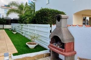 a brick oven sitting next to a white fence at Villa Crystal by Ezoria Villas in Coral Bay