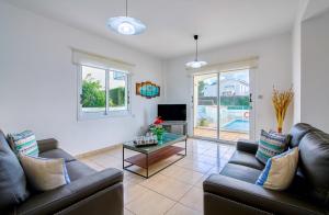 sala de estar con 2 sofás y TV en Villa Crystal by Ezoria Villas en Coral Bay