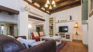 ein Wohnzimmer mit Couch und Fernseher in der Unterkunft La Hospedería de los templarios de Toledo - Apartamentos Aloha Toledo in Toledo