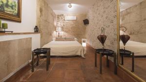 Habitación con cama, 2 mesas y espejo. en La Hospedería de los templarios de Toledo - Apartamentos Aloha Toledo, en Toledo