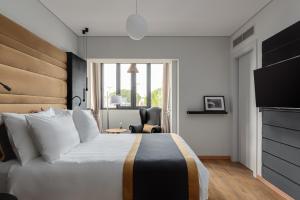 una camera con un grande letto e una sedia di Athenian Riviera Luxurious Residence ad Atene
