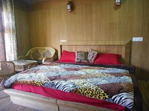 a large bed with a colorful blanket on it at Nandan Kanan Auli Resort in Joshīmath