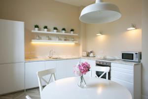 una cocina con una mesa con un jarrón de flores. en Auldhame House East Wing, Seacliff, en North Berwick