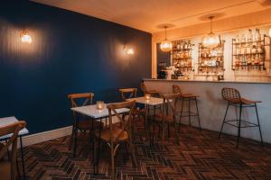 a restaurant with tables and chairs and a bar at The Bay Hotel in Coverack