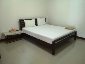 a bed with white sheets and a book on it at Pruksa Resort Prachin Buri in Prachin Buri