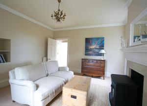 a living room with a white couch and a fireplace at Auldhame House East Wing, Seacliff in North Berwick