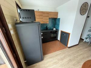 a small kitchen with a refrigerator in a room at le rocher saint pierre 1H - 6pers in Valloire