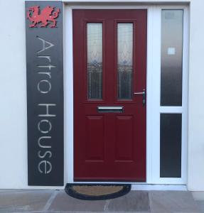 a red door on the side of a building at Artro House in Pembrokeshire