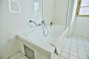 a white bathroom with a shower and a sink at U Schnellu in Prague